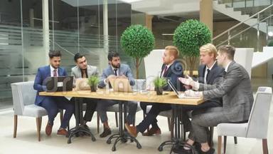 规划新项目。 国际会议。 年轻的谈判者聚集在一起讨论使用笔记本电脑的新项目。